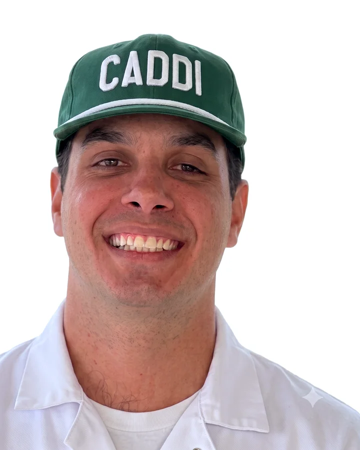 Caddi crew member in the green CADDI cap and white caddie uniform
